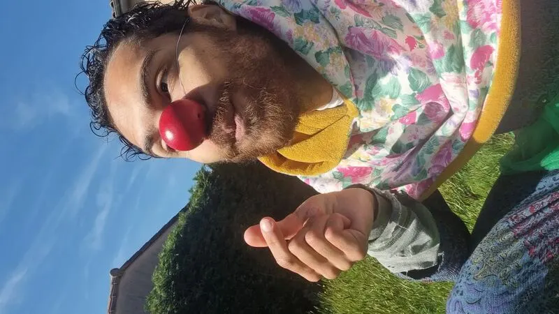 Vie, en clown rouge dans l'herbe